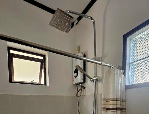 a shower head in a bathroom with a window at Cleon Villas Pension in Puerto Princesa City