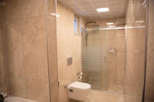 a bathroom with a toilet and a glass shower at Adenz Otel in Elmadağ