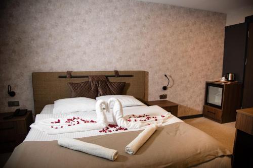 a bedroom with a bed with towels on it at Adenz Otel in Elmadağ