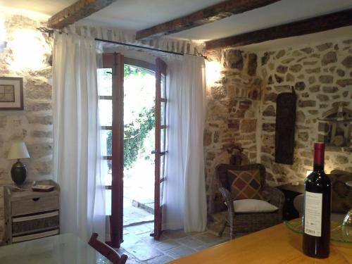 a wine bottle on a table in a room with a window at Hvar Architect's House in Pitve