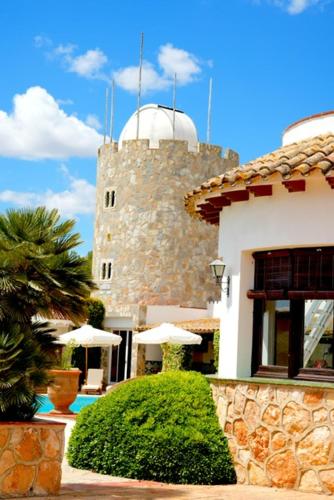 a building with a building with a clock tower at Mas Boronat Resort in Salomó