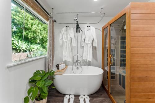 a bathroom with a white tub and a window at Summerland SeaSpa Retreat | The Chosen Collection in Summerland