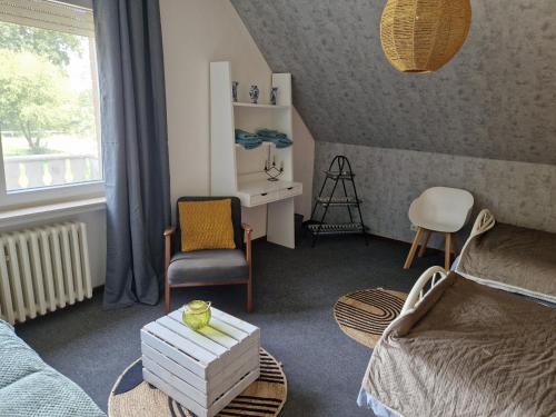a room with a bed and a chair and a desk at Ruhige Ferienwohnung an der Vechte - Zweites Glûck in Nordhorn