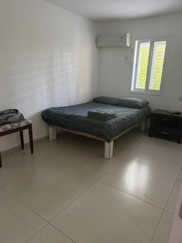 a room with two beds and a window at Hamsa Apartment in Menaẖemya