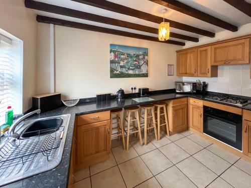 a kitchen with wooden cabinets and a counter top at Bacchus Cottage - Uk51964 in Sutton on Sea