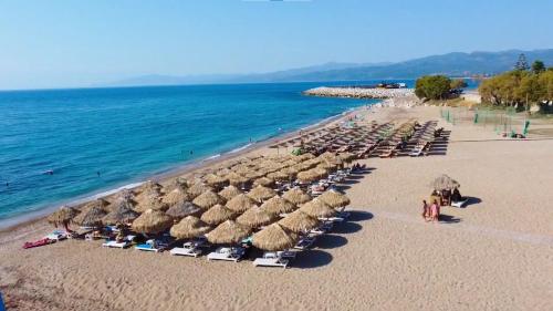 a group of umbrellas and chairs on a beach at Stone Family Home Garden Center Beach in Kyparissia