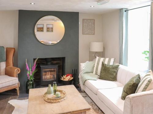 a living room with a white couch and a fireplace at Brynawel in Maenclochog