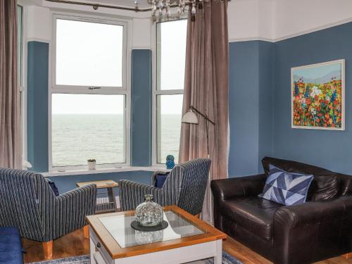a living room with a couch and two chairs at Bay View - Uk52077 in Criccieth