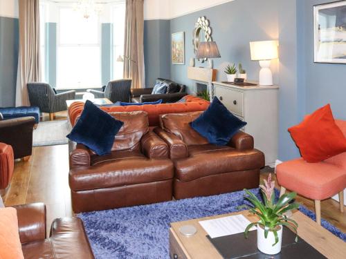 a living room with a brown leather couch at Bay View - Uk52077 in Criccieth