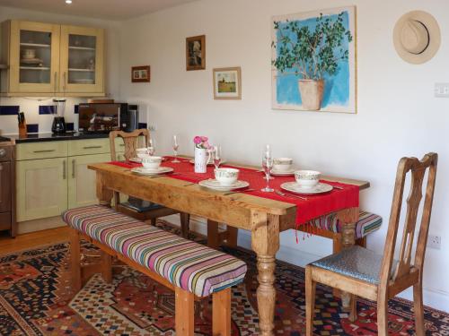 a kitchen with a wooden table and two chairs at The Quarry Stables in Cheddar