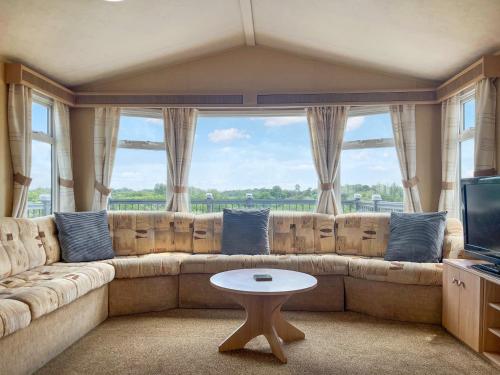 a living room with a large couch and a table at Valley View - Uk52130 in Oakmere