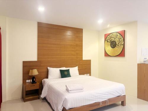 a bedroom with a large bed with a wooden headboard at Baan Phu Place in Ban Suan
