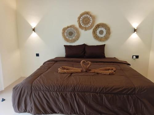 a bedroom with a bed with two brown comforters at VIA Homestay 1 in Kuta Lombok