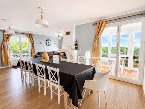 a dining room with a black table and white chairs at Panorama d'EXCEPTION vue Dunes & Mer centre et plage à pied La Crête des Dunes Maison complète ou APT uniquement in Le Touquet-Paris-Plage