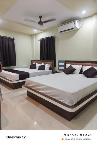 three beds in a room with a fan at Hotel PANDIT PALACE in Visakhapatnam