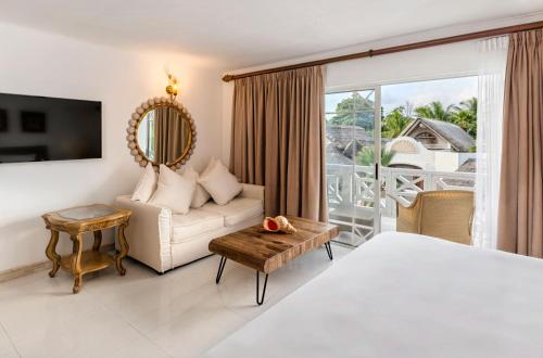 a bedroom with a bed and a couch and a window at Village du Pecheur in Baie Sainte Anne