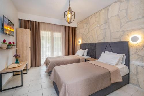 a hotel room with two beds and a stone wall at Μυρτιές-Mirties in Siviri