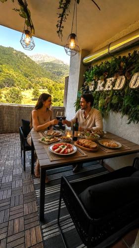a man and woman sitting at a table with food at Gredos Starlight House in Mijares