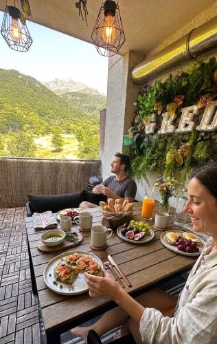 a man and woman sitting at a table with food at Gredos Starlight House in Mijares
