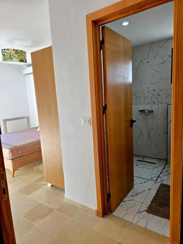 a bathroom with a door leading to a bedroom at S2 vip nouvelle soukra in Sukrah