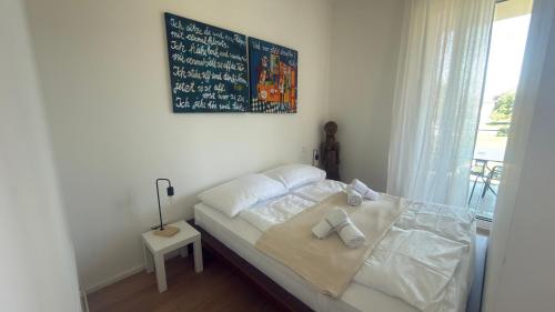 a bed in a room with a board on the wall at Hermitage Apartment E03B - Seeblick & Zugang in Maria Wörth