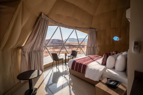 a bedroom with a bed and a large window at Valley Resort in Wadi Rum
