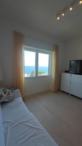 a bedroom with a bed and a large window at Il Piccolo Cristallo sul Mare in Santa Marinella