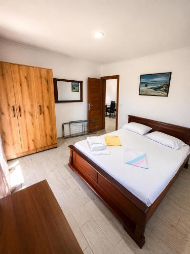 a bedroom with a large bed with white sheets and a table at Bayview in Grabe
