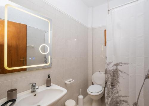 a bathroom with a sink and a toilet and a mirror at Μυρτιές-Mirties in Siviri