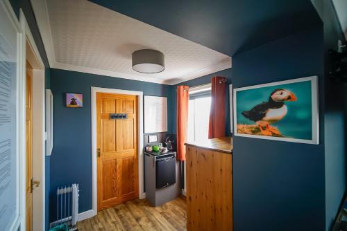 a blue room with a picture of a duck on the wall at Burnside Cottage in Wick