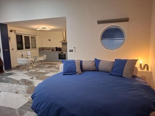 a large blue bed in a room with a kitchen at Suite Romantique in Saint-Romans