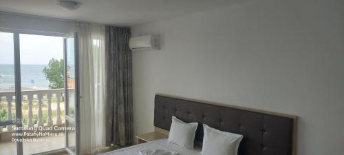 a bedroom with a bed with a view of the ocean at Apartman RS 27 Апартамент на плажа с вълшебна гледка към морето, напълно оборудвана кухня и безплатен паркинг, със самостоятелен басейн, балкон и асансьор Самостоятелен душ и тоалетна ТОП местоположение in Lozenets