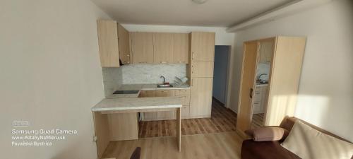 a kitchen with wooden cabinets and a counter top at Apartman RS 27 Апартамент на плажа с вълшебна гледка към морето, напълно оборудвана кухня и безплатен паркинг, със самостоятелен басейн, балкон и асансьор Самостоятелен душ и тоалетна ТОП местоположение in Lozenets