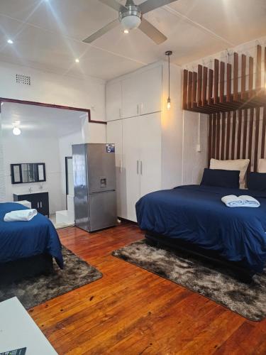 a bedroom with two beds and a refrigerator at Ludiz Self Catering Accommodation in Avondale