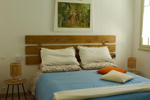 a bedroom with a blue bed with two pillows at Casa Arcobaleno in Marsala