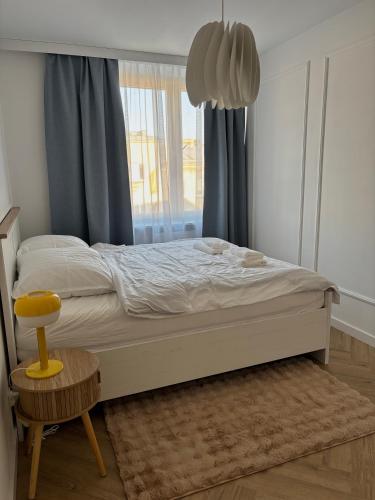 a bedroom with a large bed with a window at WOW Apartament in Białystok