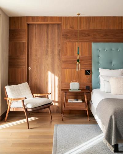 a bedroom with a bed and a chair and a table at Coeur de Megève in Megève