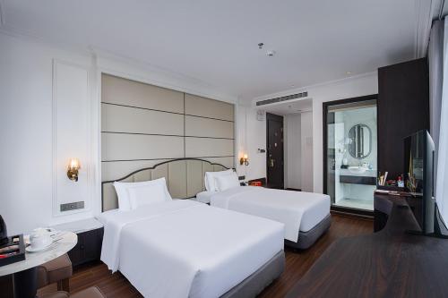 a hotel room with two beds and a television at A25 - Premium Hotel - 95 Lò Đúc in Hanoi