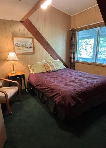 a bedroom with a bed in a room with a window at Historic Big Mountain Chalet Upper in Whitefish