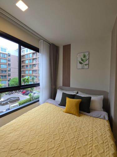 a bedroom with a bed and a large window at Cozy Minimalist apartment in Kathu