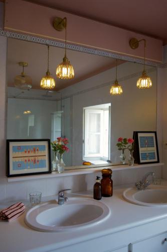 a bathroom with two sinks and a large mirror at Maison Flora Saint Jean d'Angely in Vervant