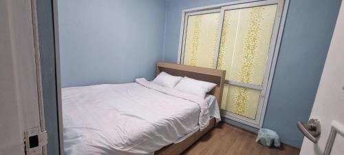 a small bed in a room with a window at Liz House in Incheon