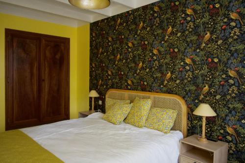 a bedroom with a bed with a floral wallpaper at Maison Flora Saint Jean d'Angely in Vervant