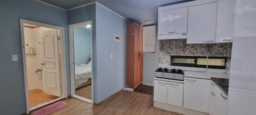 a kitchen with white appliances and a room with a bed at Liz House in Incheon