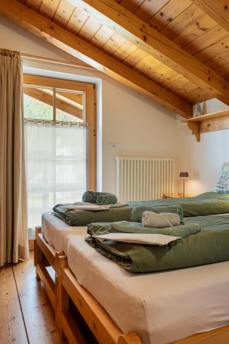 a group of four beds in a room with a window at La Culla Stube in Padola