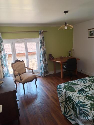 a bedroom with a bed and a desk and a chair at Gîte du piémont in Mouzon