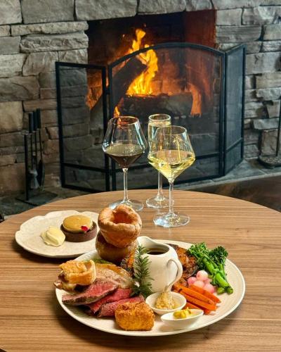 a table with a plate of food and two glasses of wine at The Beaconsfield Hotel in Fremantle