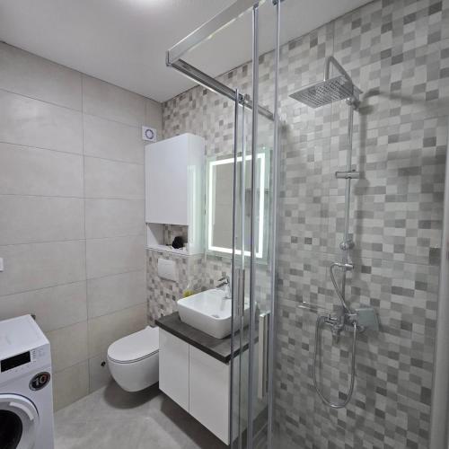 a bathroom with a shower and a sink and a toilet at Lux apartmani Anastasija in Sutomore