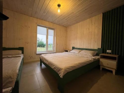 a bedroom with a large bed and a window at Wald Haus in Pulʼmo