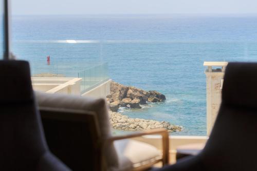 a view of the ocean from a room with chairs at Olymp Luxury Residence in Kissonerga
